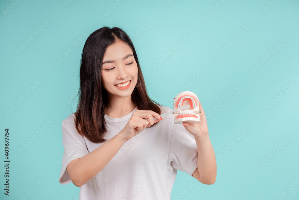 Dental Beautiful smiling of young asian woman teach correct teeth brushing and toothbrush for white teeth increase confidence for healthy on blue background isolated, Happiness facial expression. Dental Beautiful smiling of young asian woman teach correct teeth brushing and toothbrush for white teeth increase confidence for healthy on blue background isolated, Happiness facial expression.