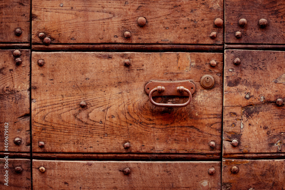 Fototapeta premium beautiful metal handle on a wooden door. beautiful retro doors. metal decoration on the door. wooden carved doors