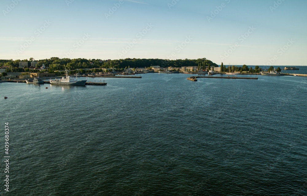 View from the ship to the port of Gdynia. Ships moored to the shore. Calm, blue water of Baltic Sea.