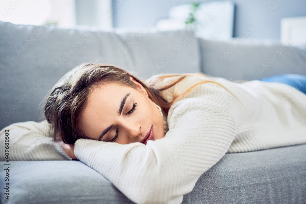 Sleeping woman taking nap on the sofa during the day