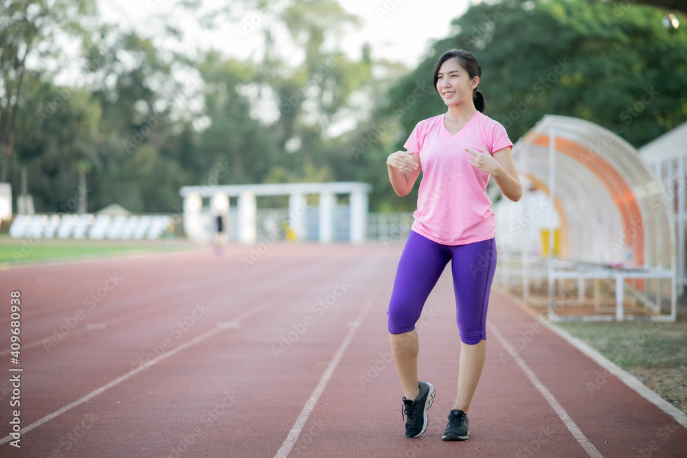 Asian girl is stretching her body warm muscles before going out for a run at the park Asian girl is stretching her body warm muscles before going out for a run at the park