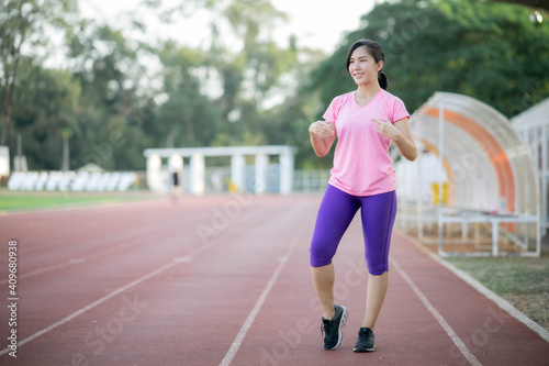 Asian girl is stretching her body warm muscles before going out for a run at the park