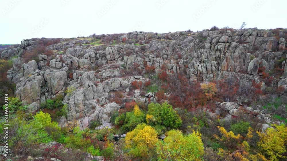 Aktovsky Canyon, Ukraine. Autumn trees and large stone boulders around. Aerial UHD 4K drone realtime video, shot in 10bit HLG and colorized Aktovsky Canyon, Ukraine. Autumn trees and large stone boulders around. Aerial UHD 4K drone realtime video, shot in 10bit HLG and colorized