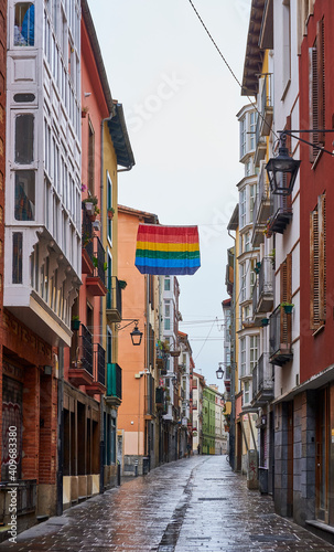 Gay pride flag waving on a rainy day, through old streets of the Vitoria-Gasteiz, Basque country 