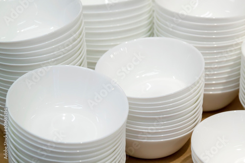 close up view of white stacks of bowls standing in rows on wooden table