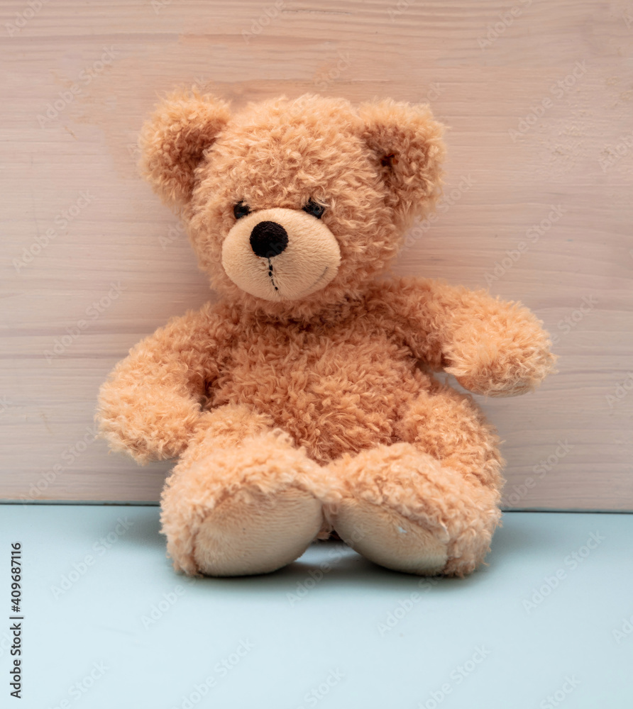Teddy bear sitting on blue floor, child room
