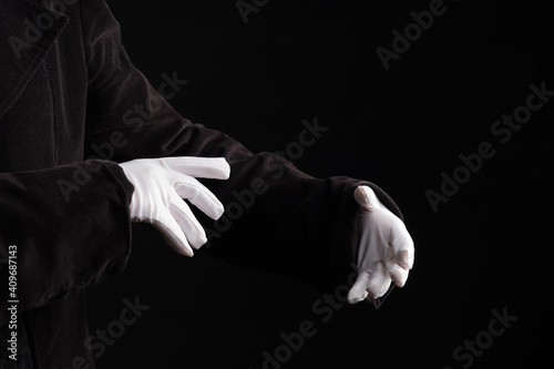 Hand gestures. spell with your hands. Showman or magician illusionist in white gloves on a black background.