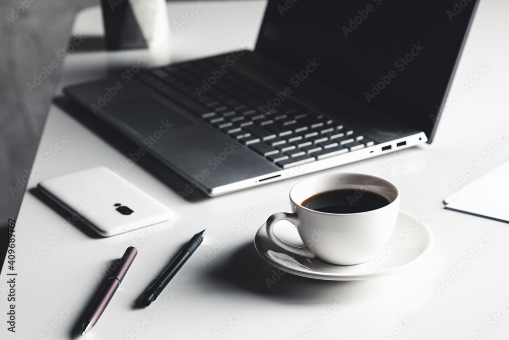 Business man using laptop computer with pen glasses and cup of hot coffee