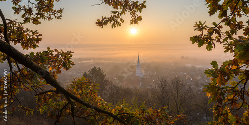 Scenic panoramic view of a sunrise over a village in a misty valley