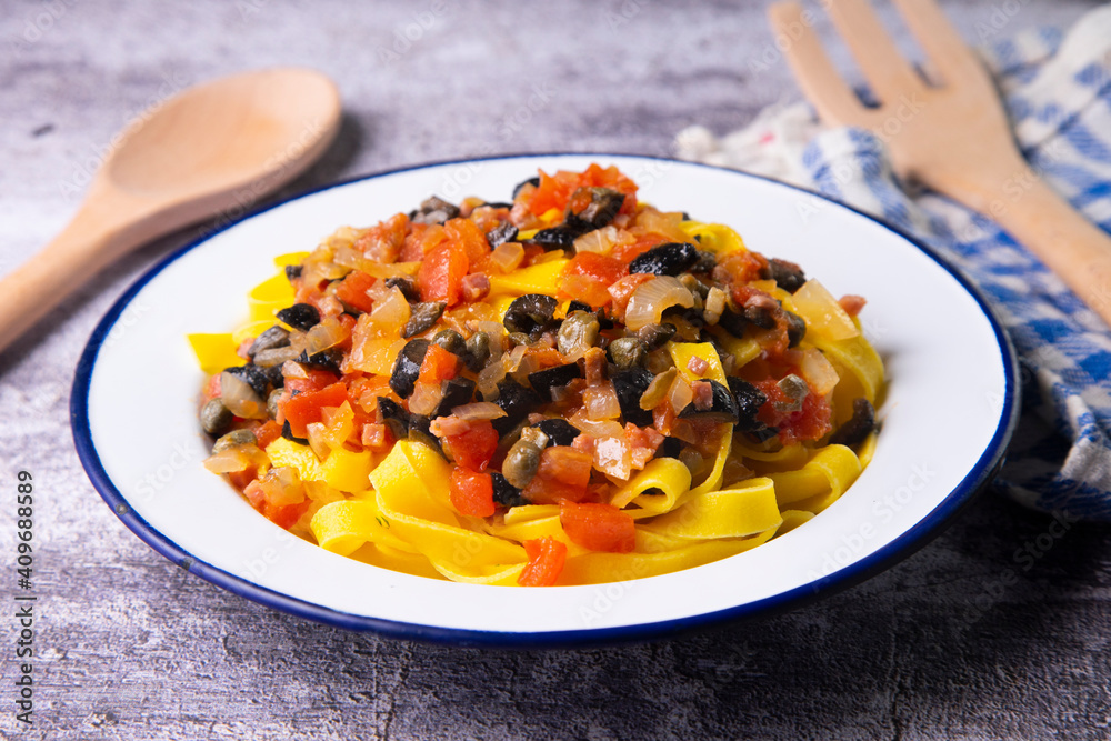 Traditional pasta with black olives and tomato