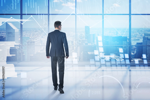 Man walking in panoramic office with graphs and cityscape