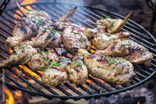 Hot and spicy chicken with rosemary and spices on grill