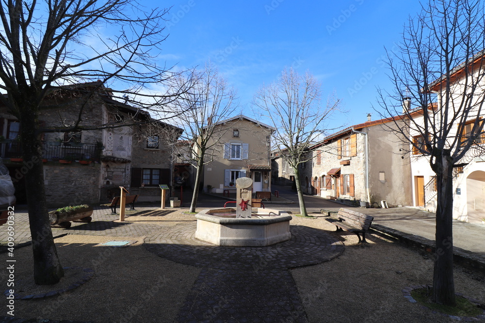 La place de l'Abbé Cougnet et sa fontaine à Saint Jean de Touslas, ville de Beauvallon, département du Rhône, France