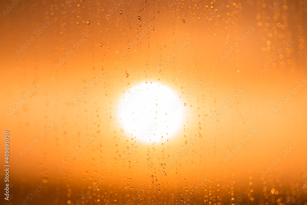 Drops on the glass against the background of an orange sunset