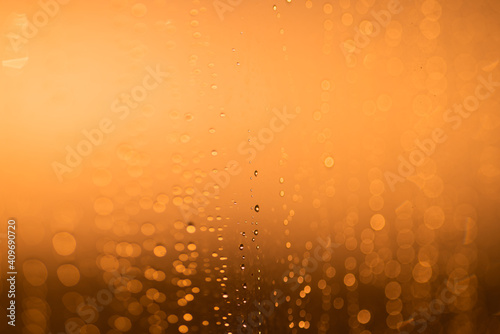 Obraz na płótnie Drops on the glass against the background of an orange sunset w salonie