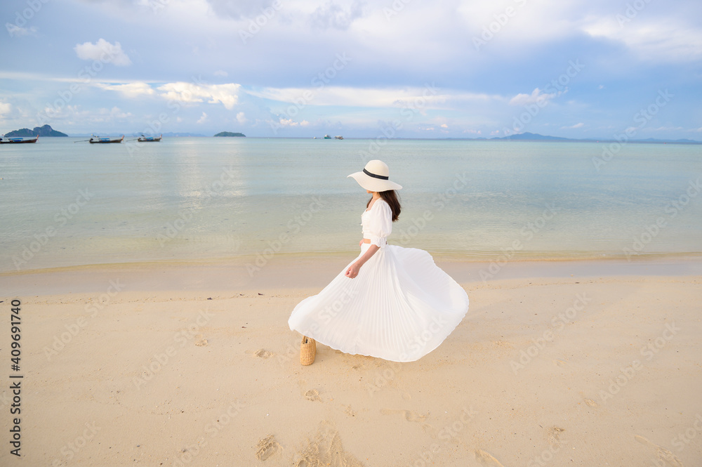 A happy beautiful woman in white dress enjoying and relaxing on the beach, Summer and holidays concept A happy beautiful woman in white dress enjoying and relaxing on the beach, Summer and holidays concept