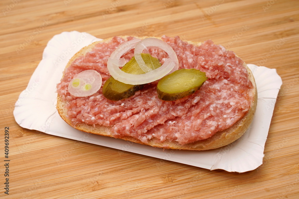 halbes belegtes Brötchen mit Hackepeter, Zwiebelmett, Pappteller halbes belegtes Brötchen mit Hackepeter, Zwiebelmett, Pappteller