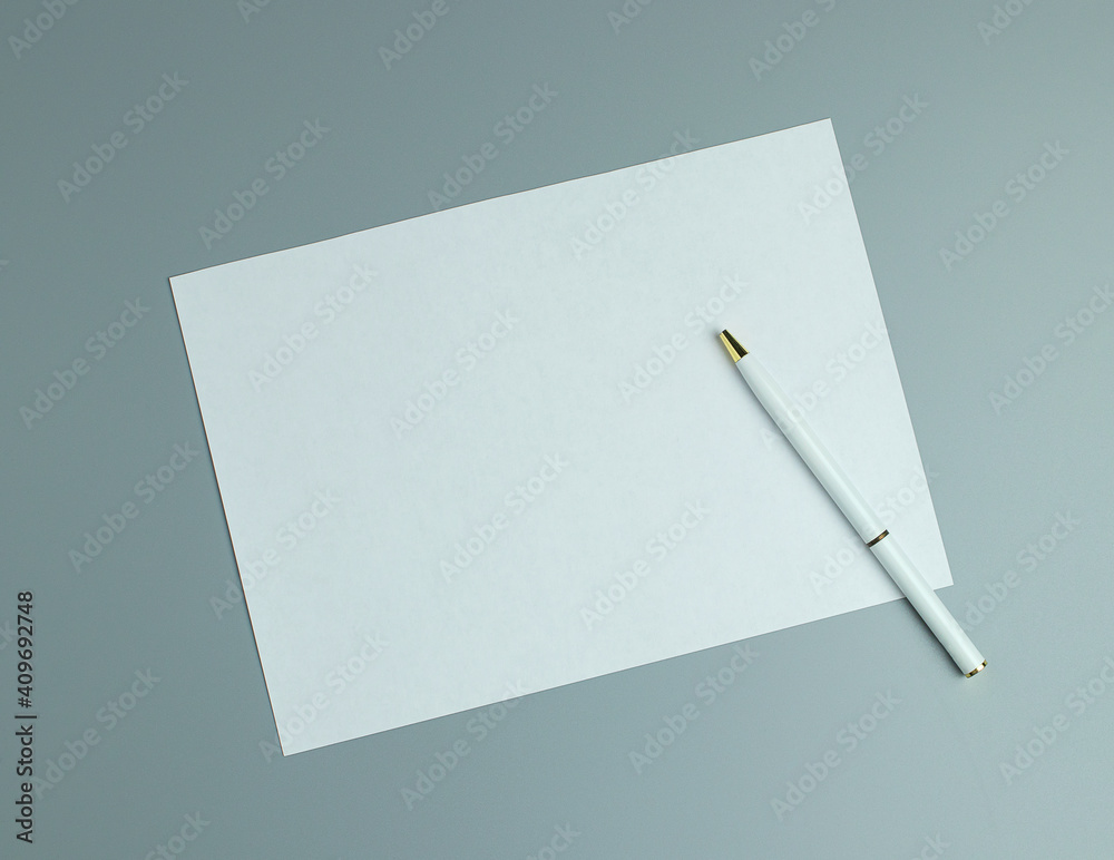 Blank white paper and white a pen on gray background. Top view Blank white paper and white a pen on gray background. Top view