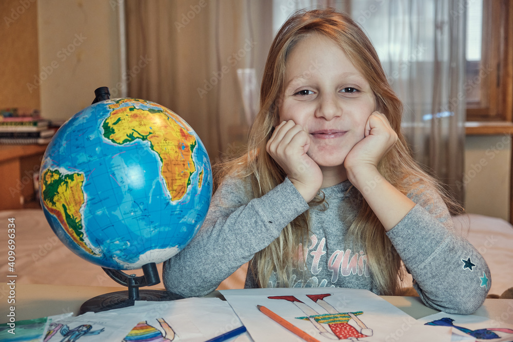 Little girl drawing on her book and having fun at playtable. Child girl does her school homework at home. Little girl drawing on her book and having fun at playtable. Child girl does her school homework at home.