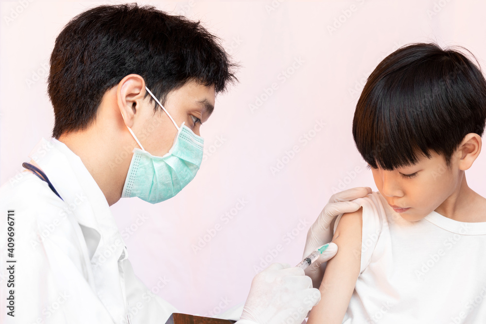 Fototapeta premium Doctor examining a child in a hospital. A happy kid is being vaccinated. doctor vaccinating little boy.