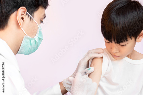 Doctor examining a child in a hospital. A happy kid is being vaccinated. doctor vaccinating little boy. © lllonajalll