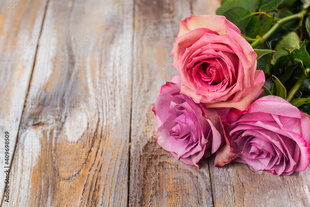 Pink roses on wooden background. Greeting card for Valentine's day, March 8th or mother's day. Copy space