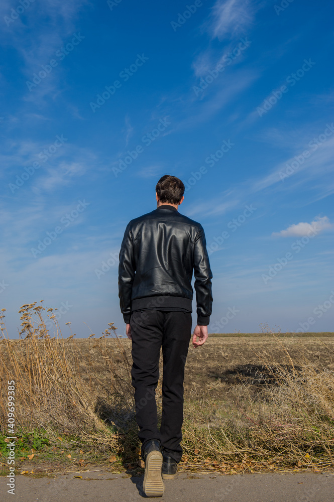 man walks in a field on a sunny day.