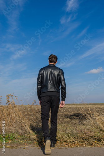 man walks in a field on a sunny day. © APHOTOSTUDIO