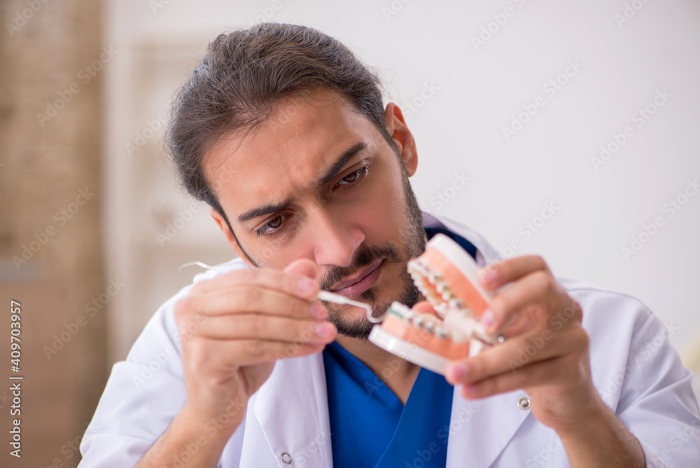 Young male dentist lecturer working in the clinic Young male dentist lecturer working in the clinic