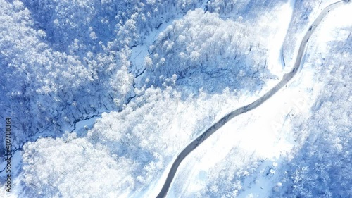 Aerial drone view of highway and  trees with snow  in the forest in winter