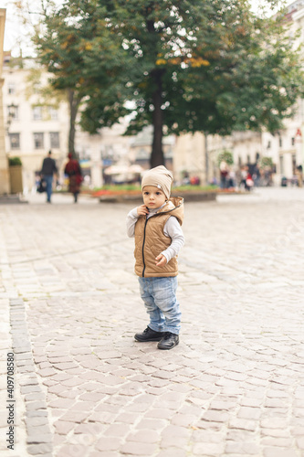 a little boy walking alone in the old town © Alexander