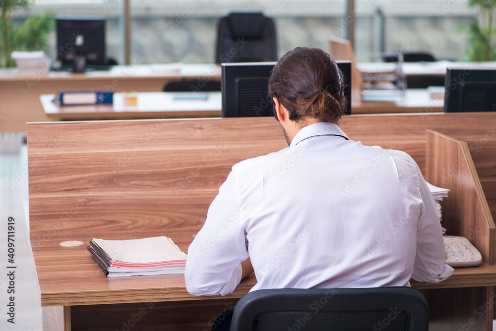 Young male employee and too many work in the office Young male employee and too many work in the office