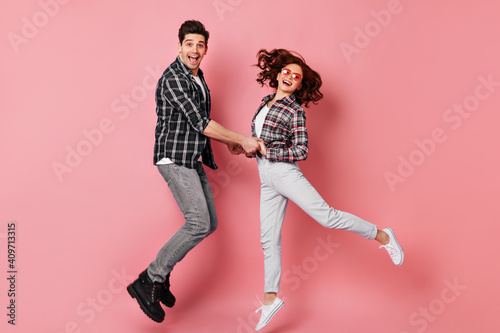 Couple holding hands and jumping. Boy funny dancing with girlfriend in valentine's day.