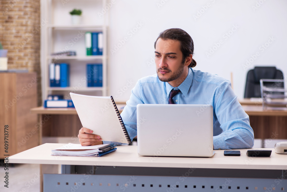 Young male employee working in the office Young male employee working in the office