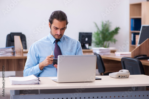 Young male bookkeeper working in the office