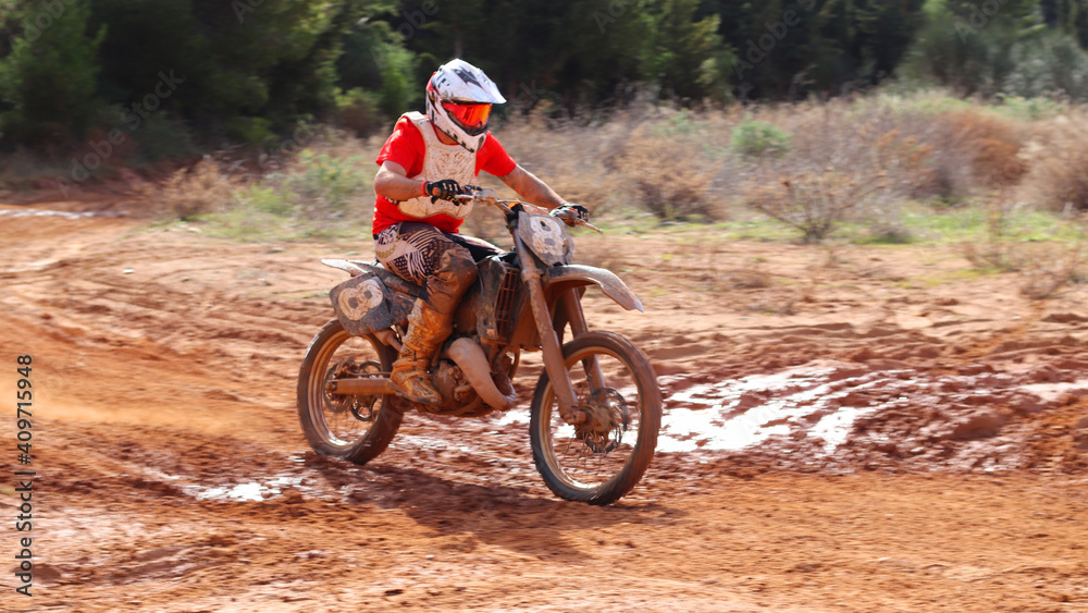 Professional dirt bike motocross rider performing stunts in extreme mud terrain track Professional dirt bike motocross rider performing stunts in extreme mud terrain track