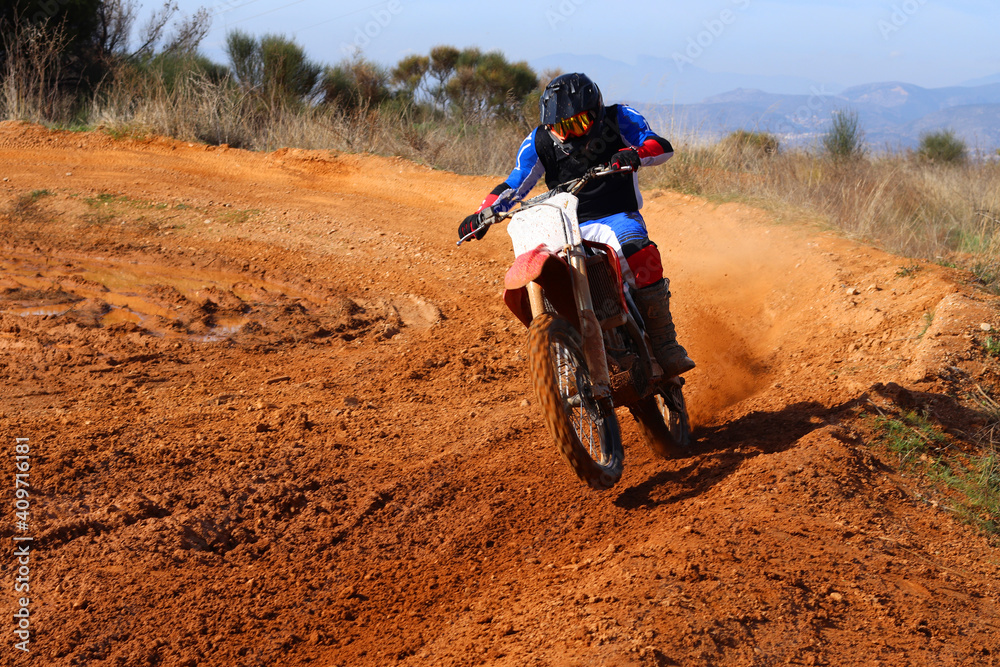 Professional dirt bike motocross rider performing stunts in extreme mud terrain track Professional dirt bike motocross rider performing stunts in extreme mud terrain track