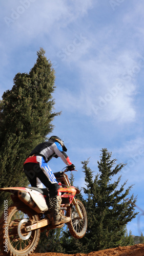 Fototapeta Naklejka Na Ścianę i Meble -  Professional dirt bike motocross rider performing stunts and flying from jump in extreme terrain track