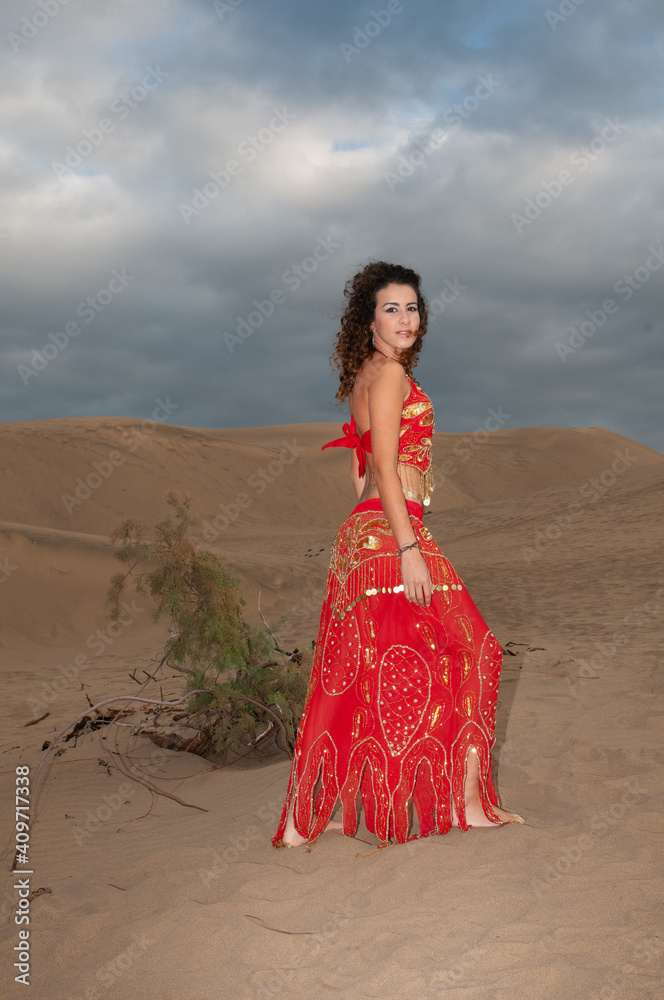 Arab belly dancer in the desert at sunset Arab belly dancer in the desert at sunset
