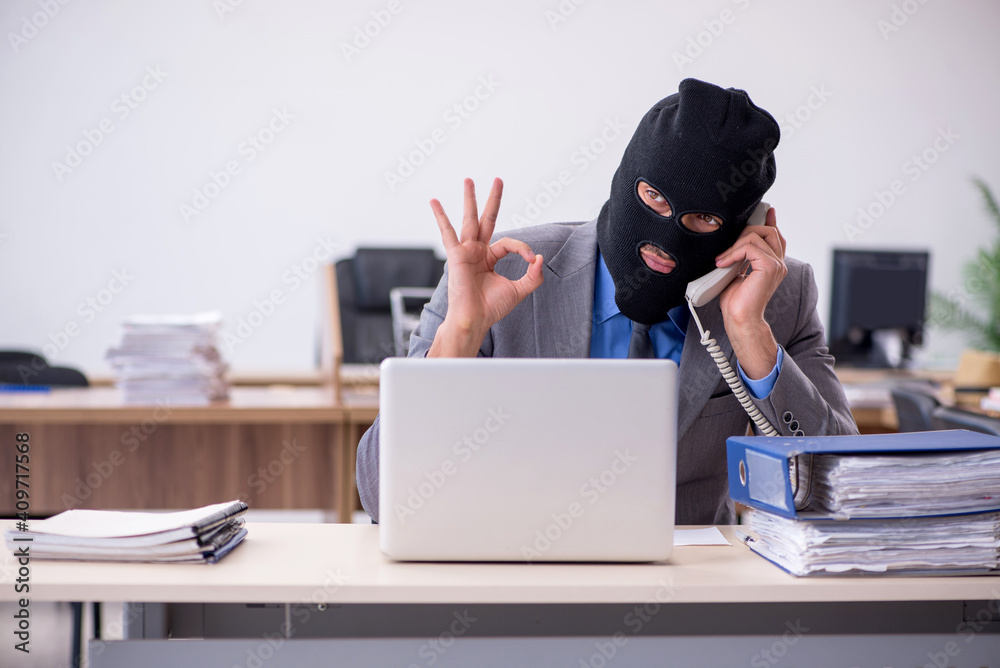 Young male employee in industrial espionage concept