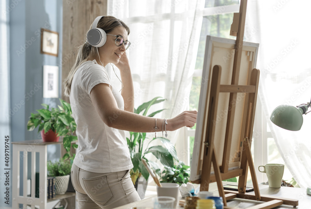 Woman listening to music and painting