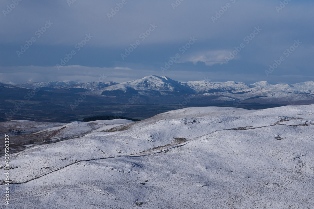Landscape view if snow covered mountains in Scotland on a bright summer day