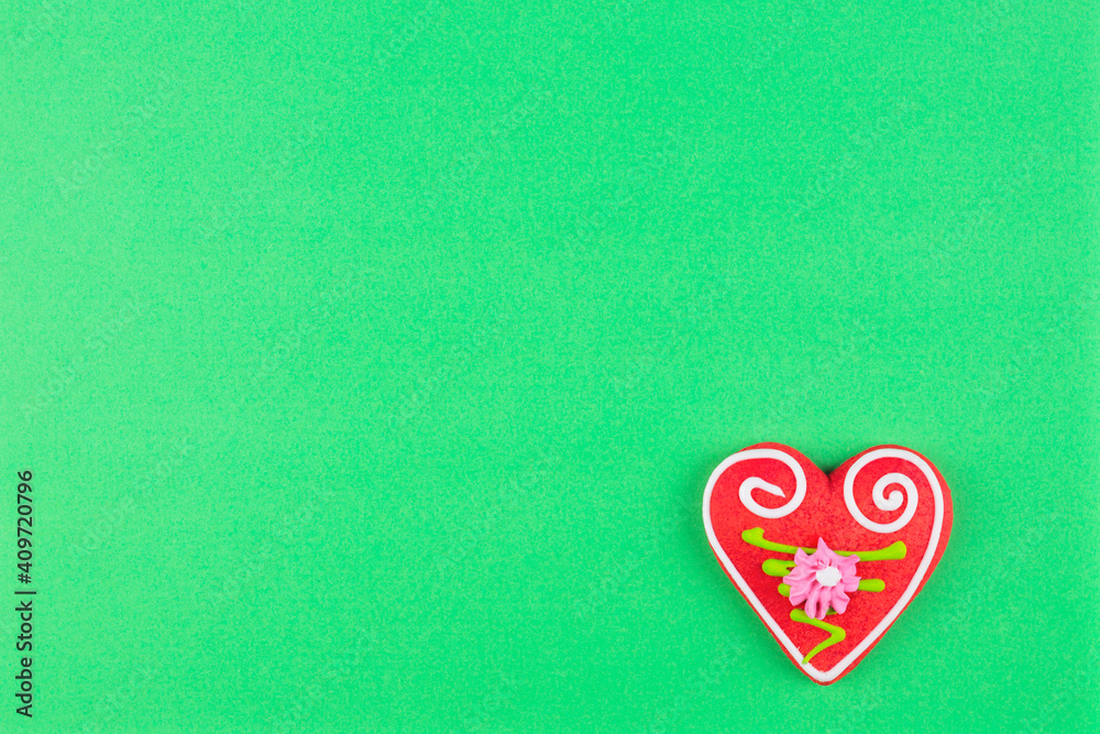 Handmade heart shaped cookie on light green background Handmade heart shaped cookie on light green background