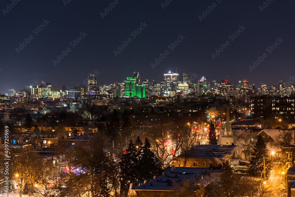 Fototapeta premium contrast of the old houses of eastern montreal and its modern downtown seen at night