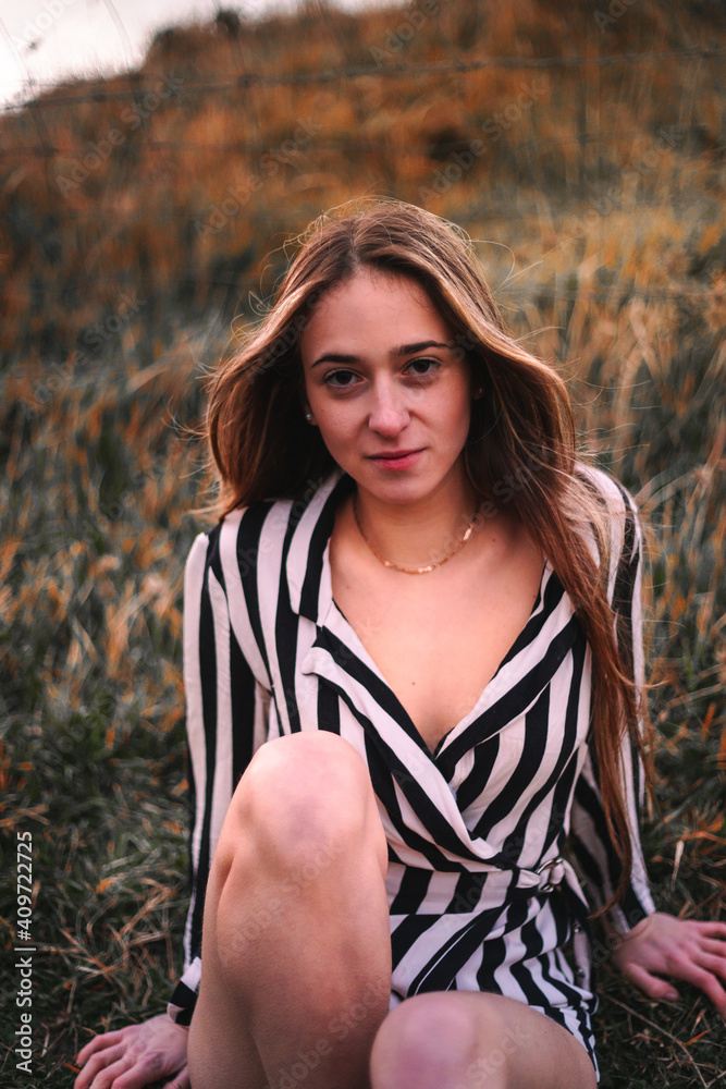 Young caucasian woman sitting a grass field. Young caucasian woman sitting a grass field.