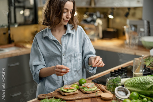 Beautiful woman with healthy green food in kitchen