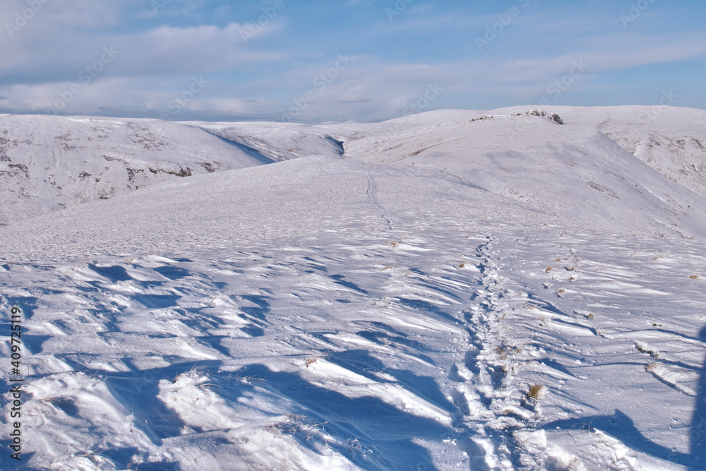 path in snow on top of snow covered Scottish Hills 