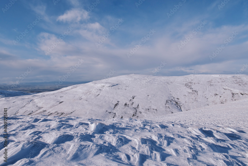 view of snow covered mountains and a valley in Scottish Ochil Hills 