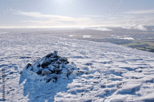 View of Forth Valley from a peak of snow covered Ochil Hills in Scotland