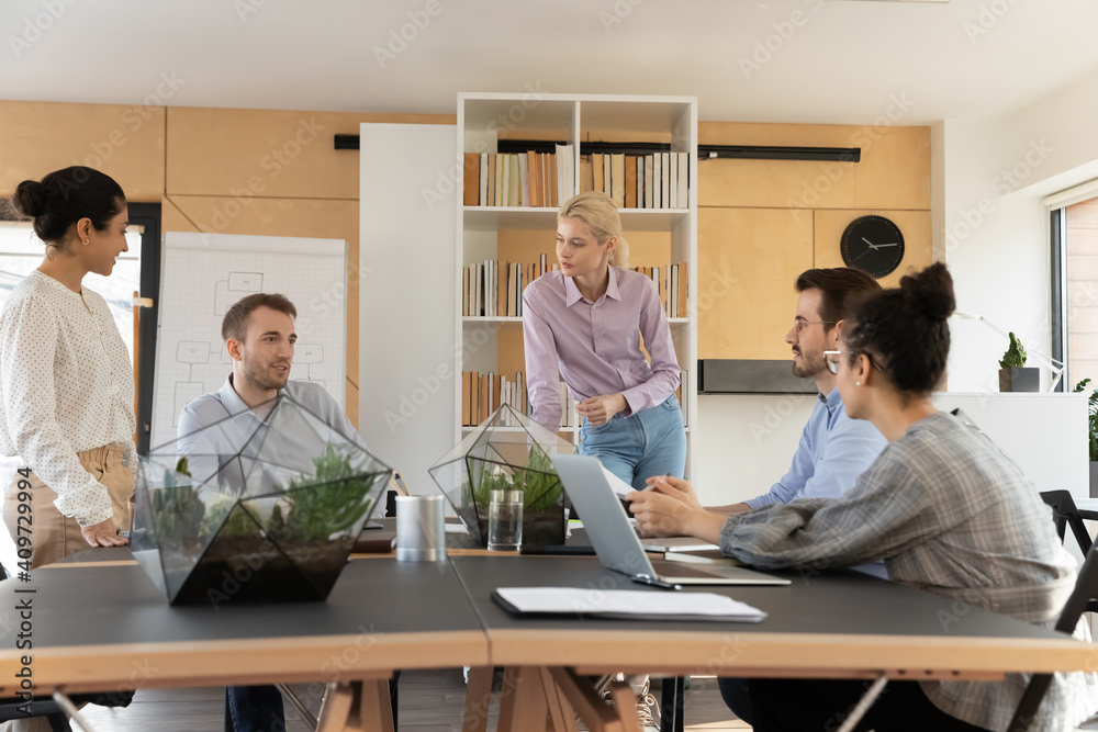 Company leaders and clients negotiating at business meeting. Diverse team of employees talking and brainstorming at workplace. Mixed raced managers discussing work and sales. Office training concept